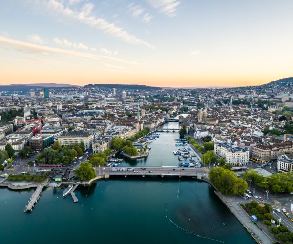 Aerial drone shot flying above Lake Zurich, Switzerland in sunny day. Beautiful landscape of a large magnificent lake and natural mountain scenery that popular place in summer in the city of Zurich.